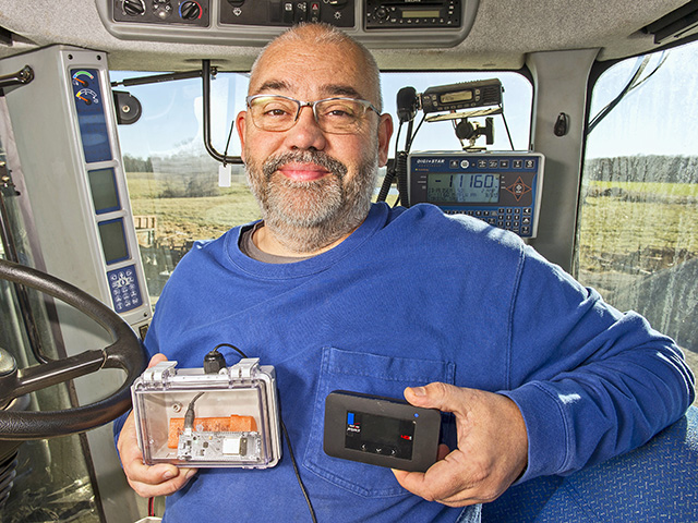 Jeremy Wilson holds the internet source and relay device that listens for beacons, Image by Mary Ann Carter